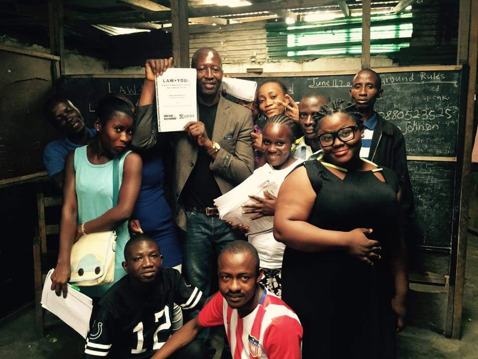 OurProgramsHero People standing while a man holds a LAW+YOU paper