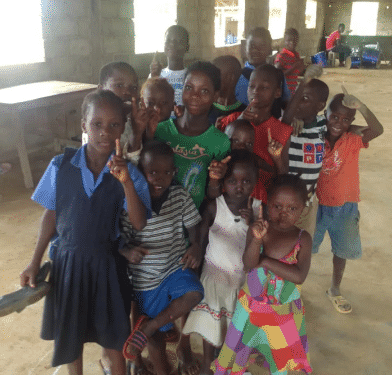 csigroupstudenphoto Children in group holding index finger up