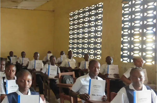 Serious students holding LAW+YOU notebooks