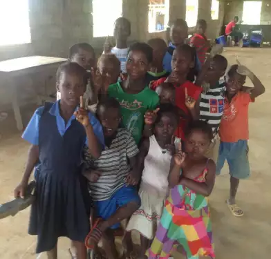 csigroupstudenphoto Children in group holding index finger up